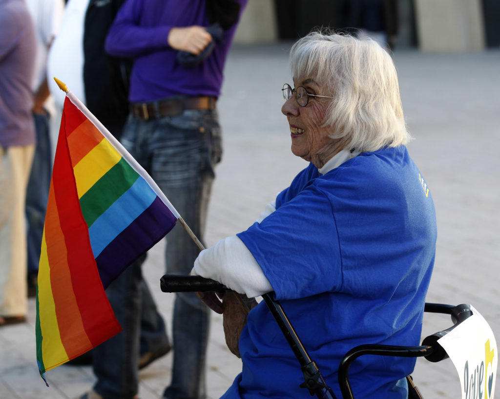 Older LGBT people like this woman holding a gay pride flag at a same-sex marriage victory celebration remain to be met.