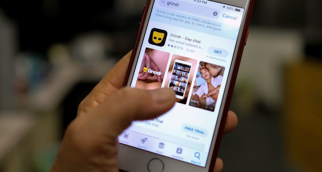 A person looks at the Grindr app in the App Store on a phone in Los Angeles on March 27, 2019.