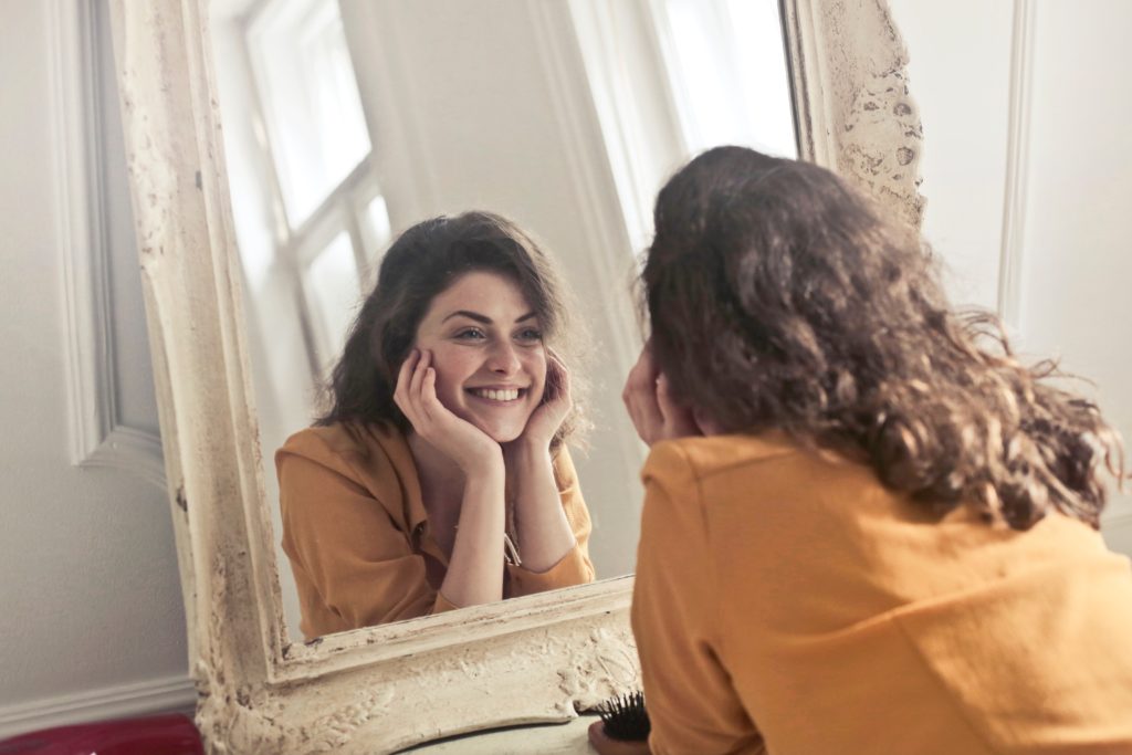 Smiling at reflection in the mirror
