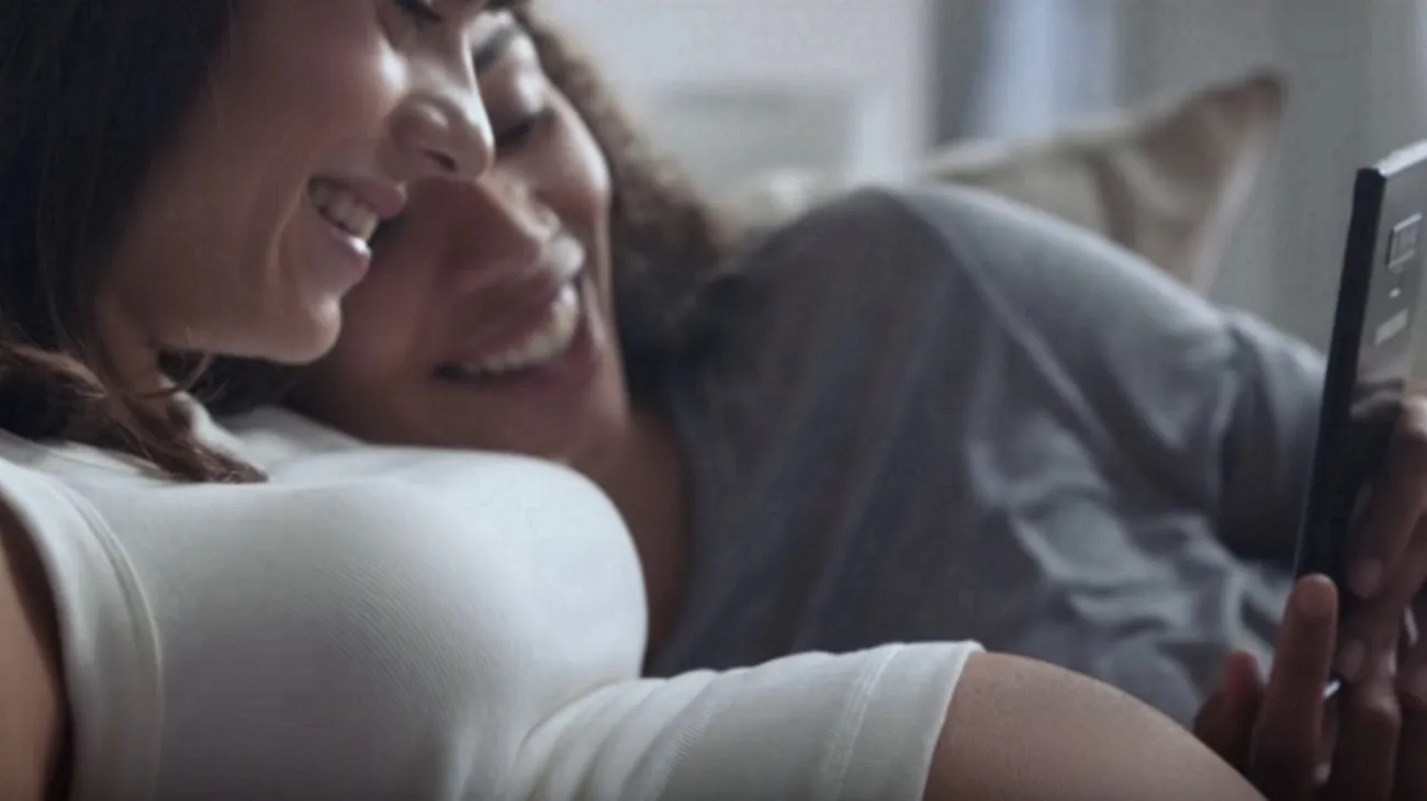 A lesbian biracial couple look at their baby on a Samsung phone in a Samsung advert