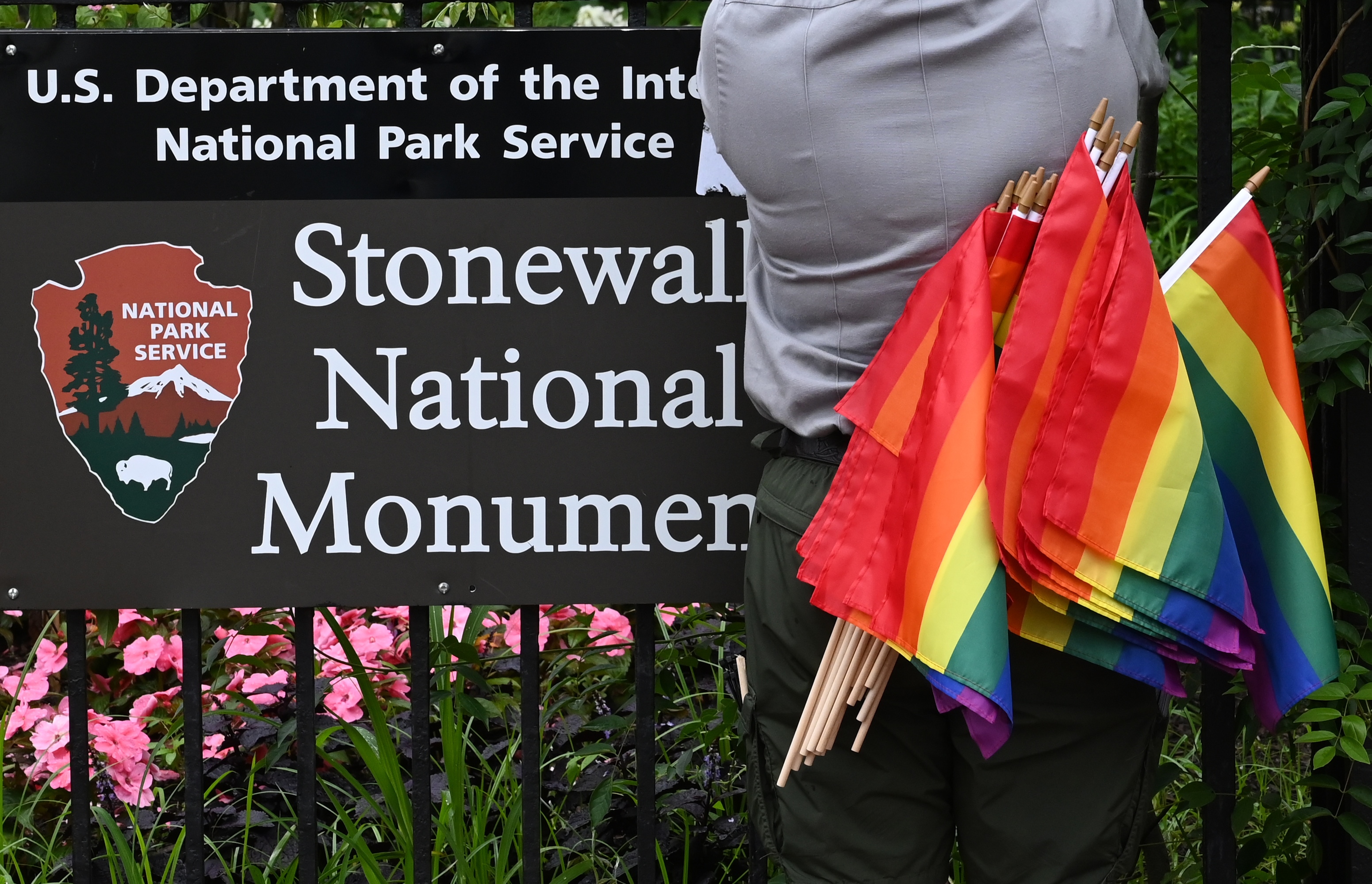 A National Park Service ranger places rainbow flags on the fence at the Stonewall National Monument in the West Village neighborhood of Greenwich Village in Lower Manhattan, New York City on June 19, 2019.