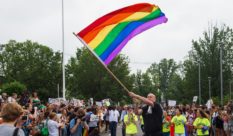 Principal Pete Cahall, waves a rainbow flag, symbolizing gay pride, at a rally of about 1000 Woodrow Wilson High School students and gay supporters June 9, 2014 at Woodrow Wilson High School in Washington, DC. The rally was held to counter a planned protest by Westboro Baptist Church, the Kansas-based organization known for anti-gay picketing at funerals. AFP PHOTO/Paul J. Richards (Photo credit should read PAUL J. RICHARDS/AFP/Getty Images)