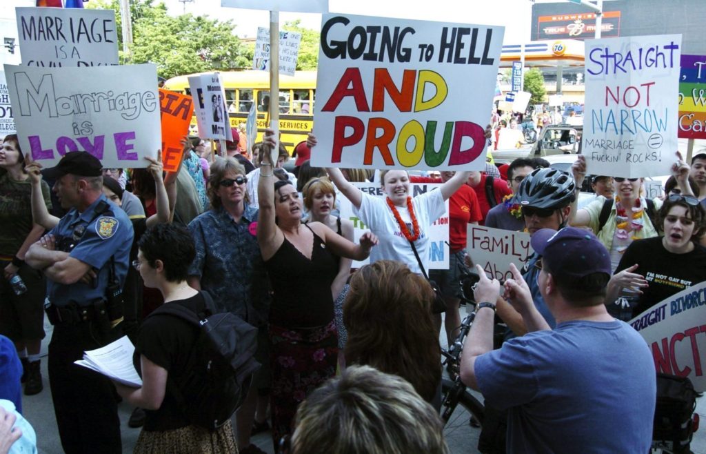 SEATTLE - MAY 1: Protestors hold signs and greet participants to a rally to affirm traditional marriage between a man and a woman on May 1, 2004 at Safeco Field in Seattle. The special speaker was James Dobson, founder of the evangelical Christian group called "Focus on the Family". The event was organized by local Christian groups and drew approximately 20,000 people as well as about 3,000 protestors, according to police. (Photo by Ron Wurzer/Getty Images)