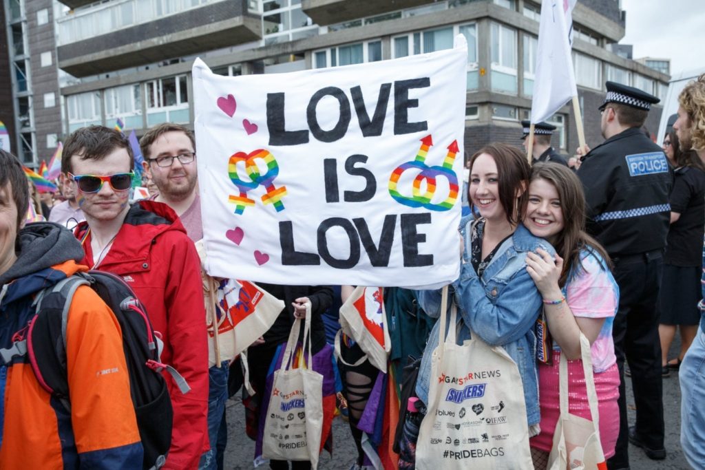 People hold up a sign during Glasgow Pride.