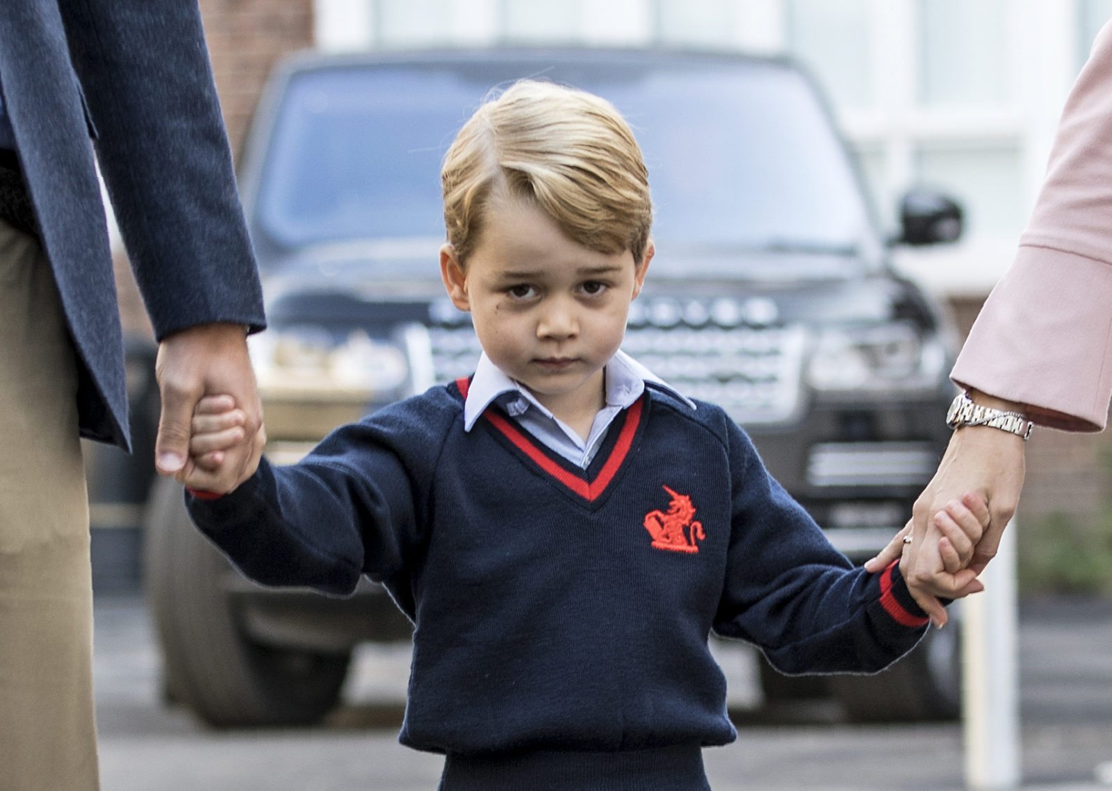 TOPSHOT - Britain's Prince George (C) accompanied by Britain's Prince William (L), Duke of Cambridge arrives for his first day of school at Thomas's school where he is met by Helen Haslem (R) head of the lower school in southwest London on September 7, 2017. / AFP PHOTO / POOL / RICHARD POHLE (Photo credit should read RICHARD POHLE/AFP/Getty Images)