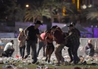 LAS VEGAS, NV - OCTOBER 01: (EDITORS NOTE: Image contains graphic content.) People carry a peson at the Route 91 Harvest country music festival after apparent gun fire was heard on October 1, 2017 in Las Vegas, Nevada. There are reports of an active shooter around the Mandalay Bay Resort and Casino. (Photo by David Becker/Getty Images)