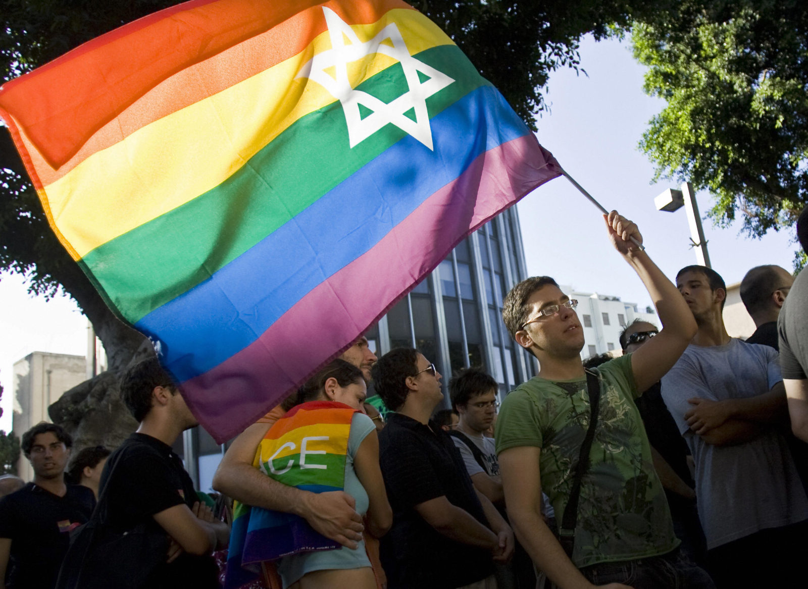 An Israeli man waves a Pride rainbow flag bearing the Star of David
