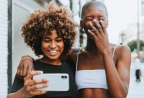 Two women smile while taking a photo of themselves