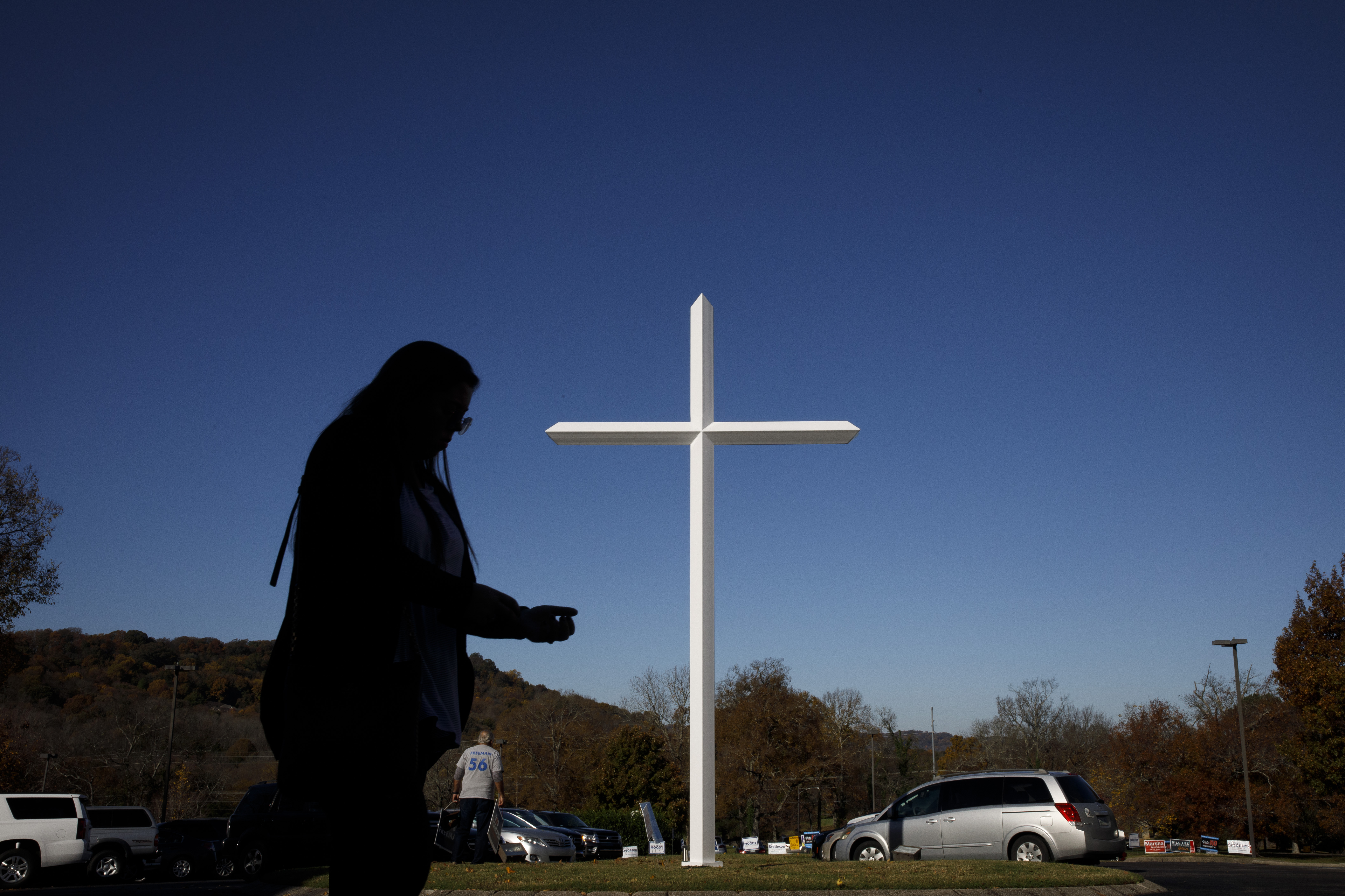 A silhouette against a white church cross