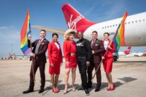 LGBT+ flight crew hold rainbow flags alongside Jodie Harsh and Tituss Burgess