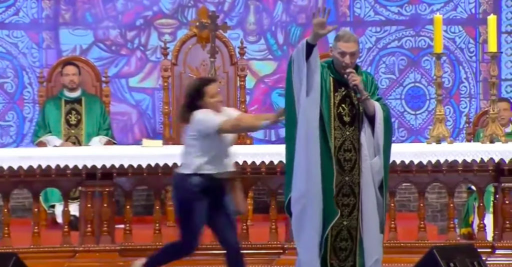 Woman pushes anti-gay priest off stage in Brazil