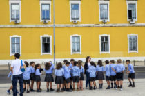 A row of school children in shorts and skirts