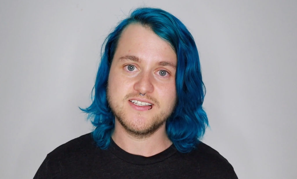 A close-up of Chase Ross, a trans man with long blue hair