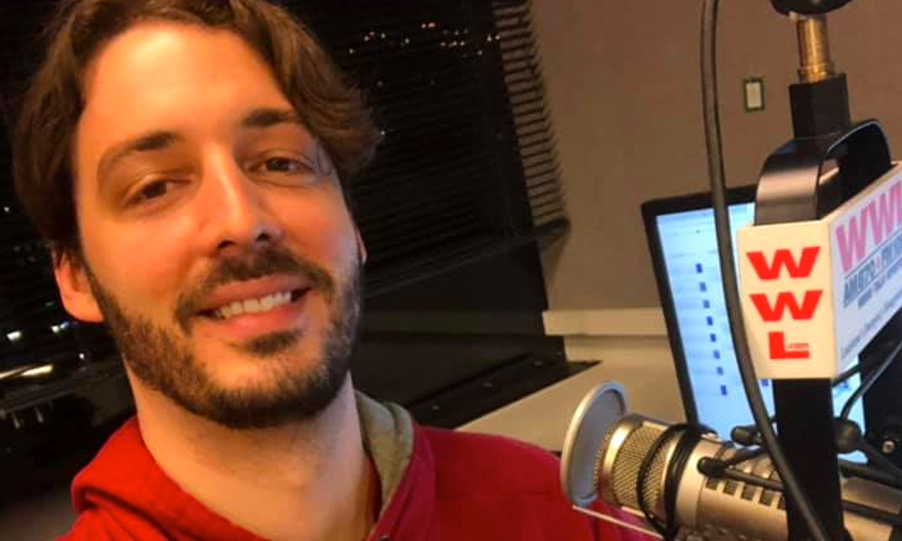 Gay radio host Seth Dunlap speaking into a radio microphone