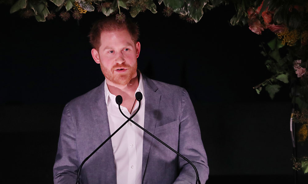 Prince Harry speaking into two microphones