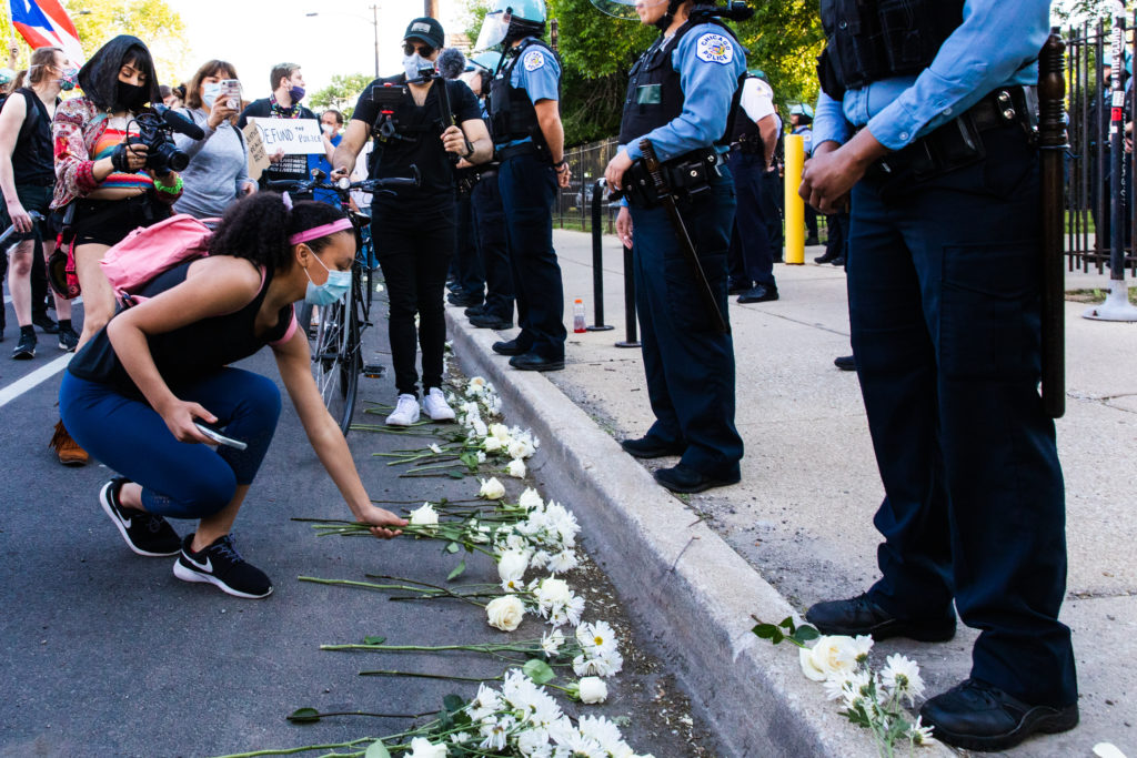 Protesters lay flowers at the feet of Chicago Police Department officers on June 06, 2020 in Chicago, Illinois.