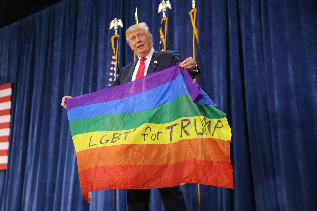 Donald Trump holds an LGBT+ Pride flag given to him by supporter. (Chip Somodevilla/Getty Images)