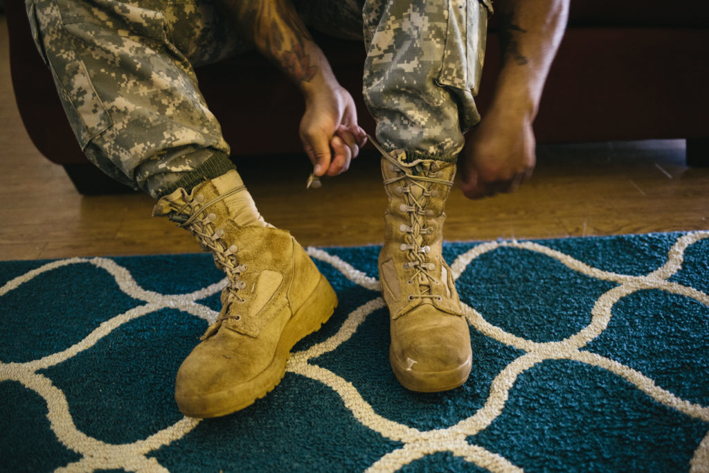 Army Sergeant Shane Ortega laces up boots before posing for a portrait at home at Wheeler Army Airfield on March 26, 2015 in Wahiawa, Hawaii.
