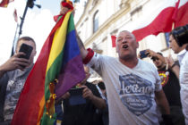 A man burns a LGBT flag during the anniversary of Warsaw Uprising in Warsaw, Poland