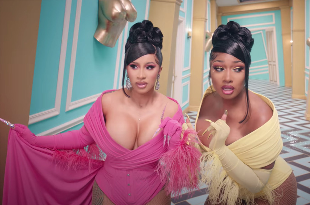 Cardi B and Megan Thee Stallion walking down a twist Alice in Wonderland-style corridor in gowns in the WAP video