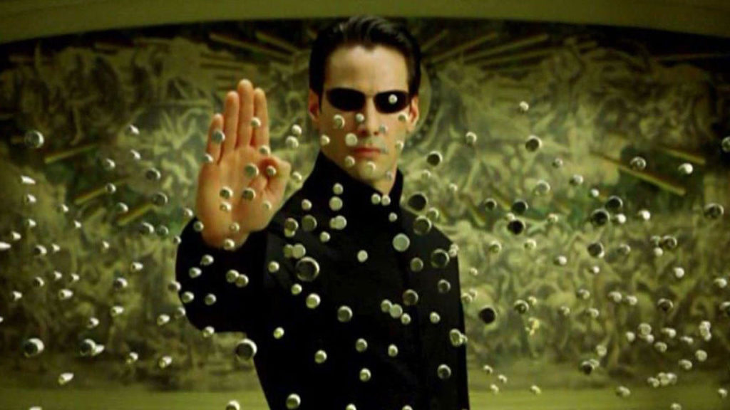 Neo holding up his palm to stop a raft of bullets