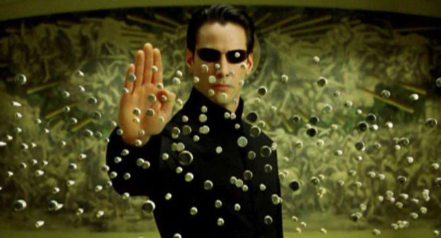 Neo holding up his palm to stop a raft of bullets