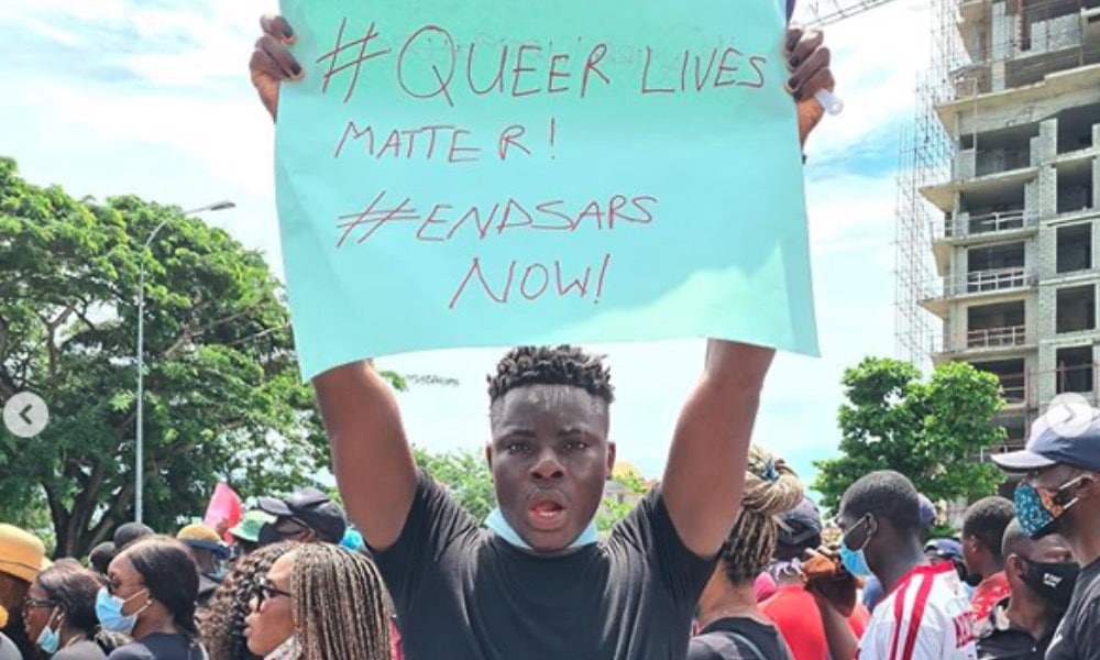 Matthew Blaise holding a placard reading 'Queer Lives Matter! End SARS now!'