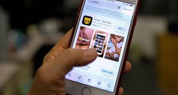 A person looks at the Grindr app in the App Store on an iPhone.