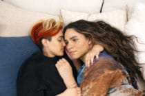 A transmasculine gender-nonconforming person and transfeminine non-binary person waking up together in bed