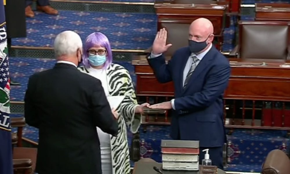 Bisexual senator Kyrsten Sinema (C) holds the Bible as Mark Kelly (R) is sworn in by Mike Pence. (Twitter)