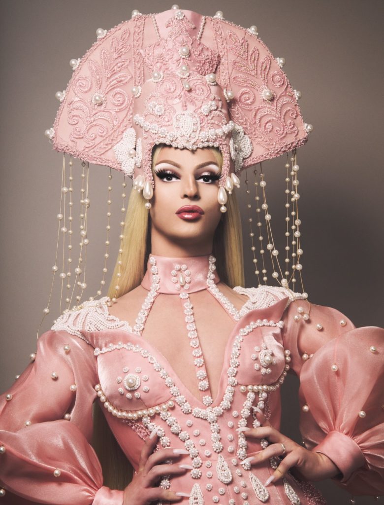 Miz Cracker in a pink pearly gown and headdress
