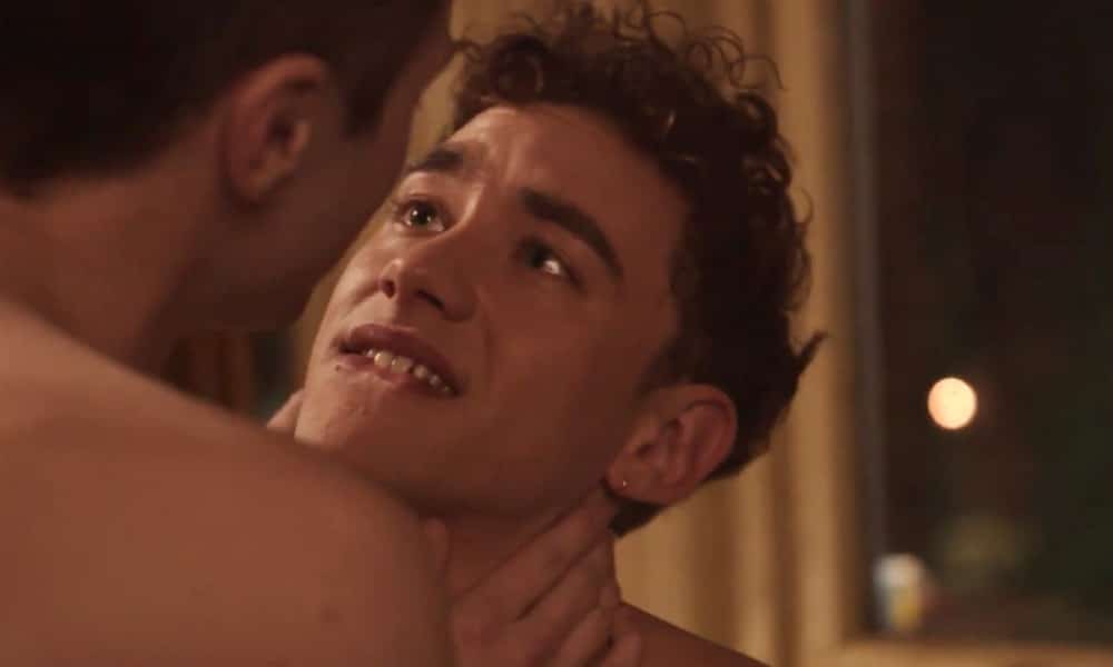 Olly Alexander biting his lip as a naked man holds him by the neck in It's a Sin