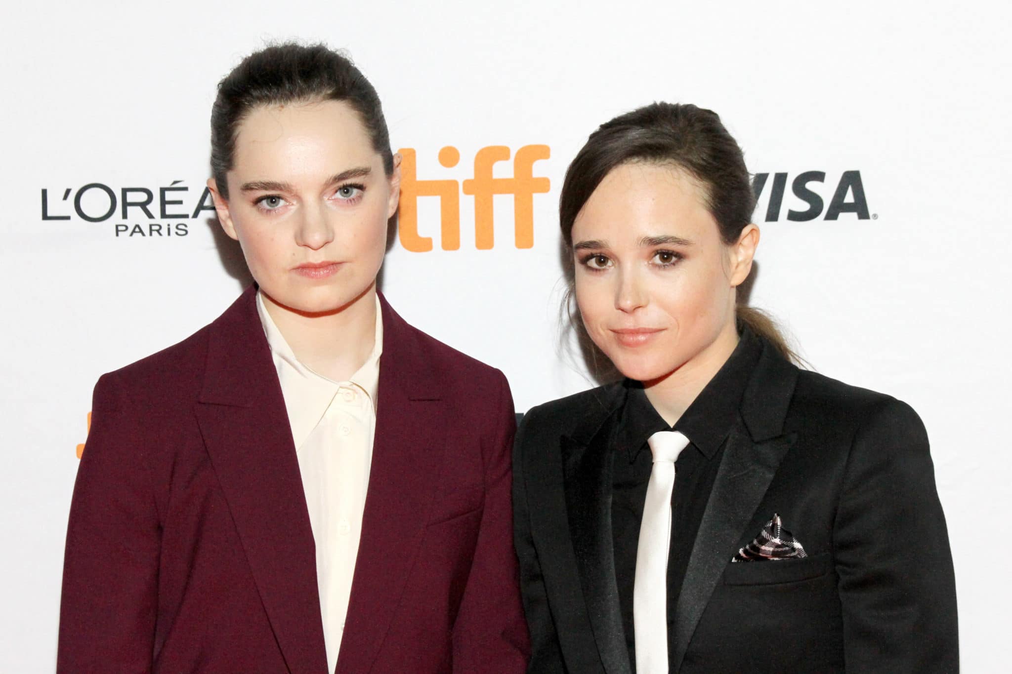 Emma Portner in a burgundy suit and Elliot Page in a black suit and white tie