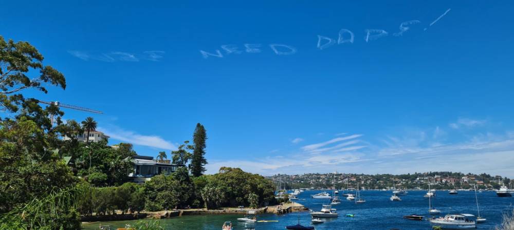message in aky above sydney Australia that says "kids need dads"