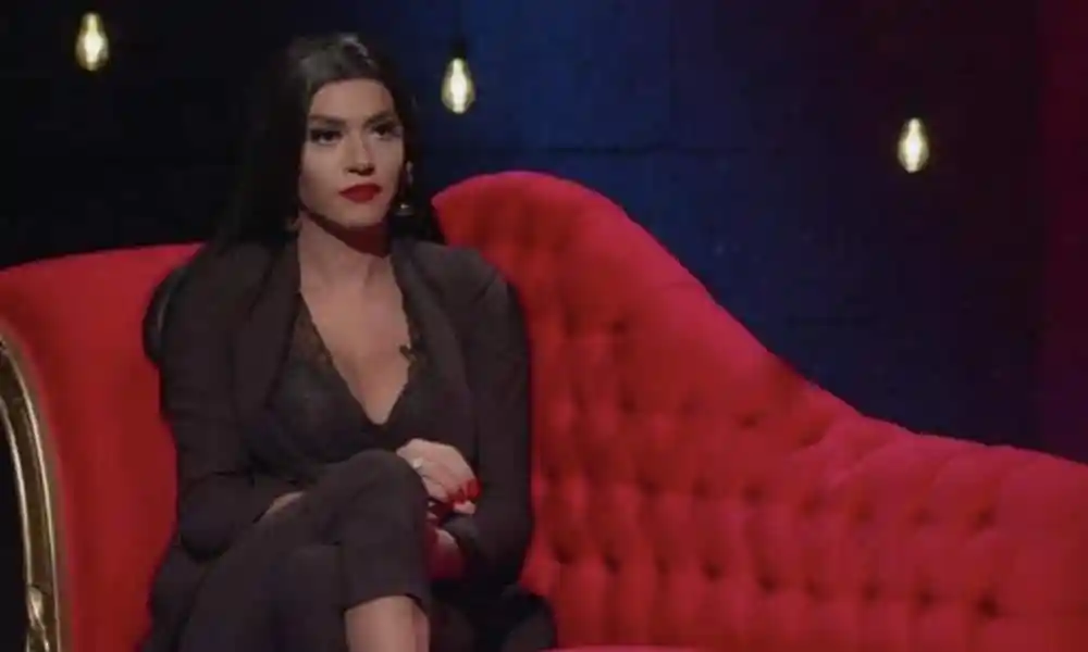 Çağla Akalın sits on a plush red couch