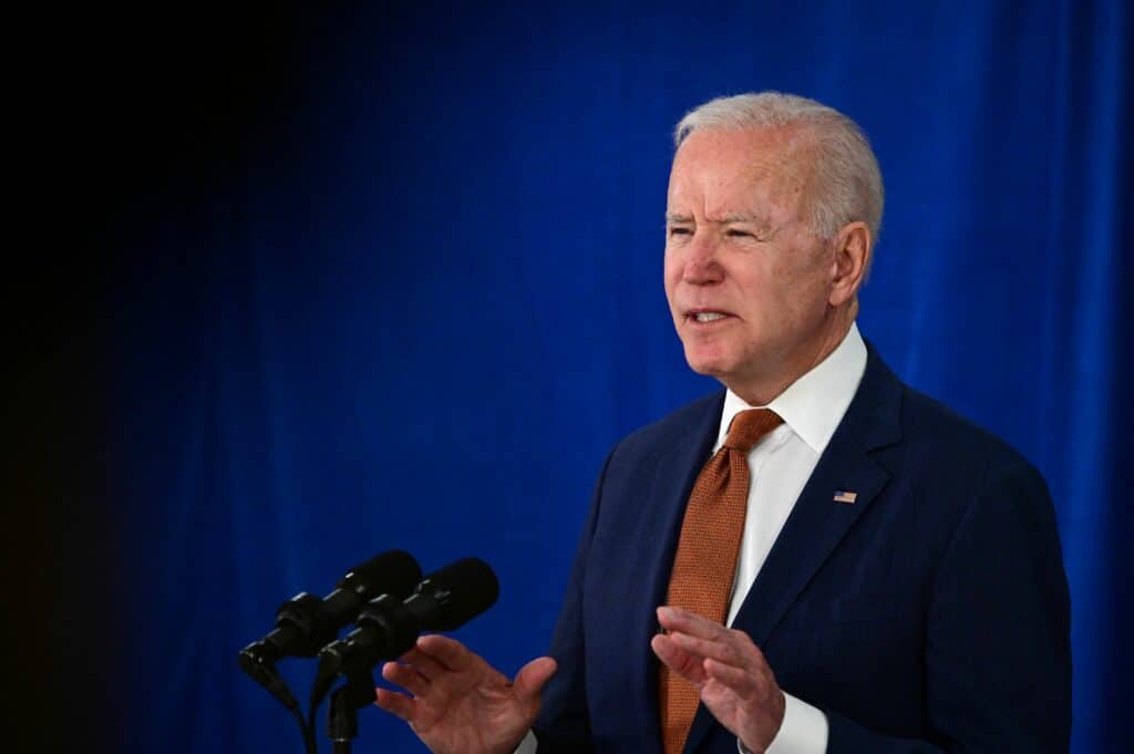 Joe Biden in a suit speaks behind a podium