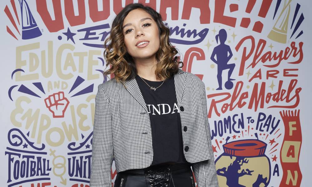 Chelcee Grimes poses in front of football graffiti artwork at FIFA