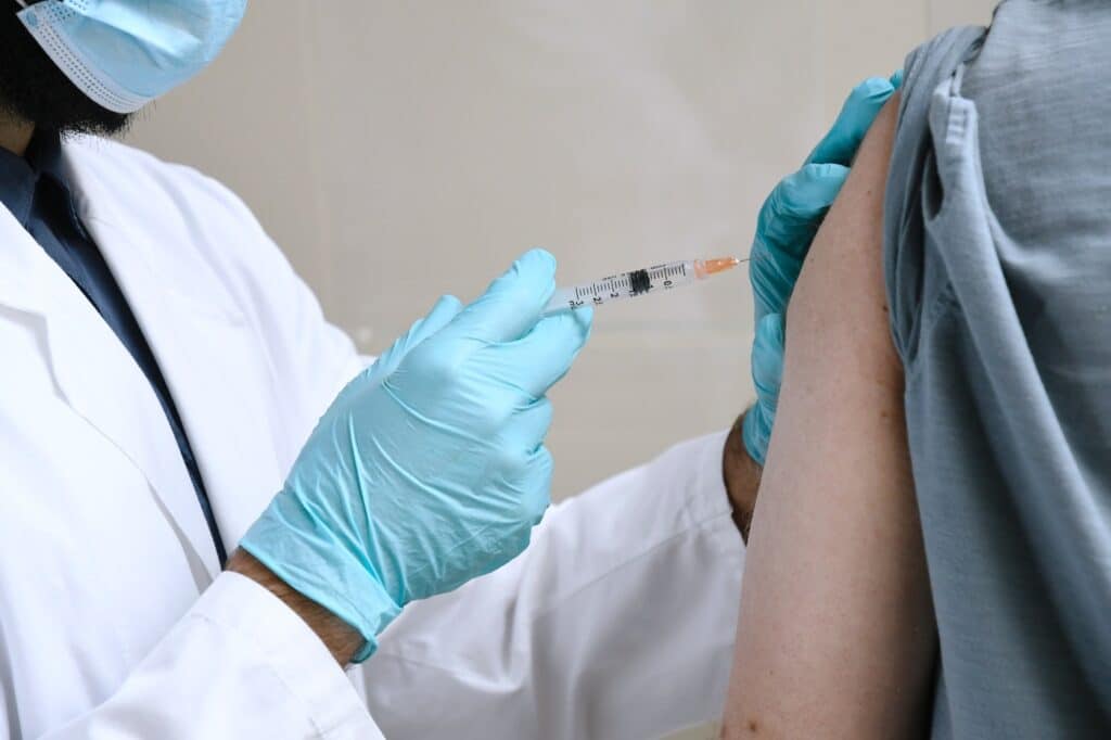 A doctor injects a person with a vaccine