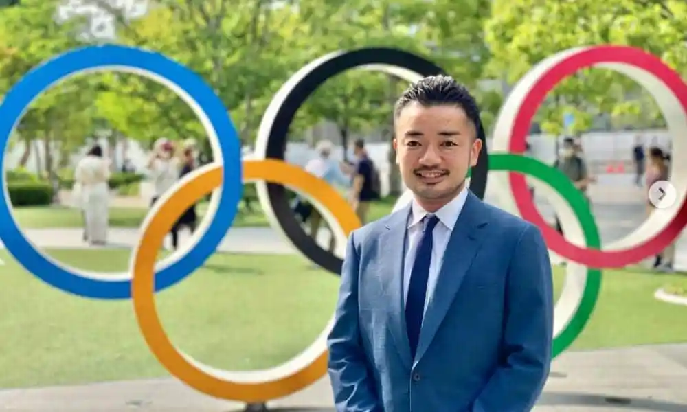 Trans activist and former fencer Fumino Sugiyama smiling in front of olympic rings