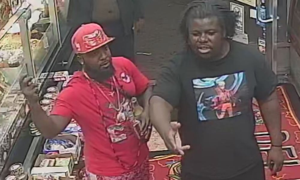 Two men, one wearing red and the other black, stand in a shop