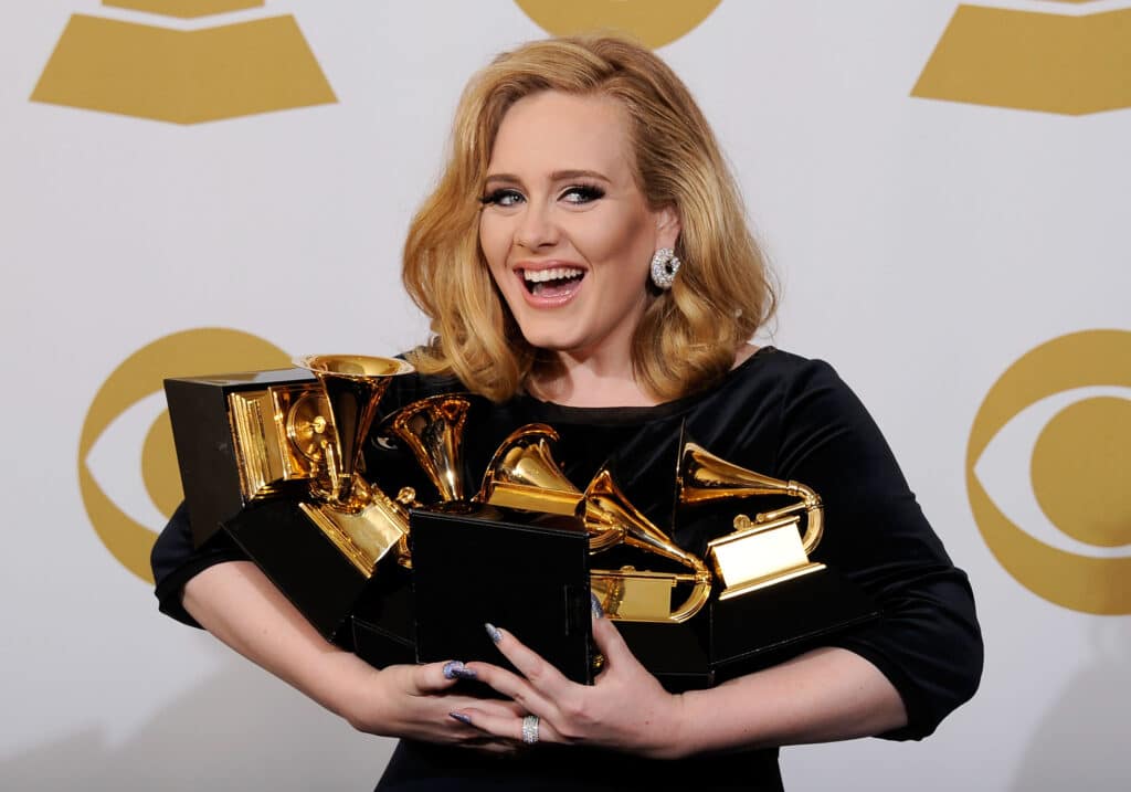 Adele holding an armful of Grammys