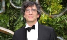 Neil Gaiman attends the global premiere of "Good Omens" in a black and white suit with a black bow tie