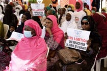 A woman in Senegal holds a sign reading 'LGBT is a threat for humanity' during a protest called by religious associations against homosexuality in 2021