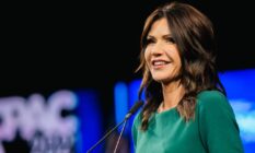 South Dakota governor Kristi Noem wears a gree outfit during her speech at the Conservative Political Action Conference on 11 July 2021
