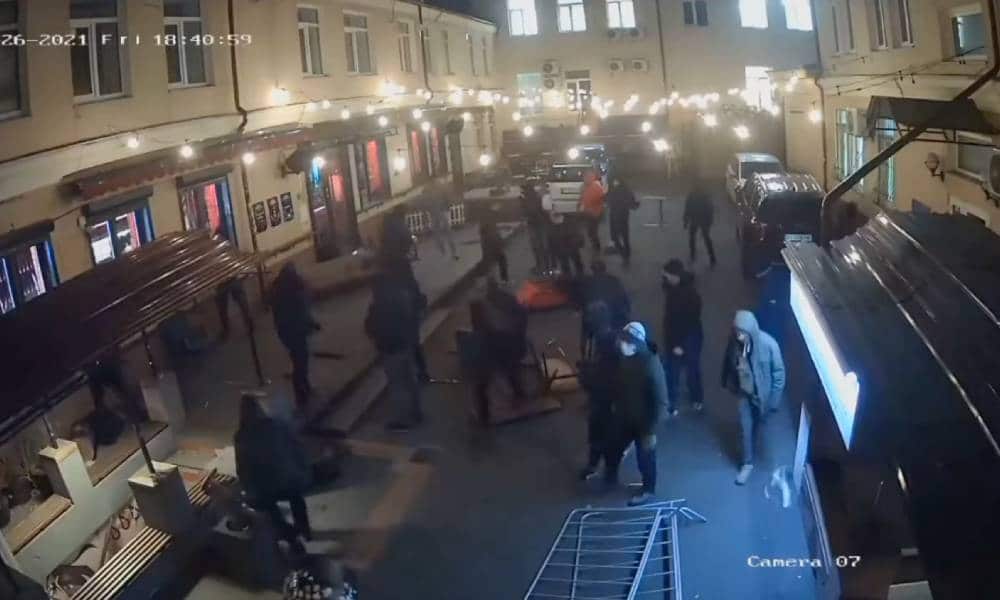 Several people in dark clothes are captured on camera destroying the outside of HvLv, a gay bar in Kyiv, Ukraine
