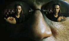 Morpheus wearing reflective sunglasses. In them, you can see Neo reaching for the Red Pill
