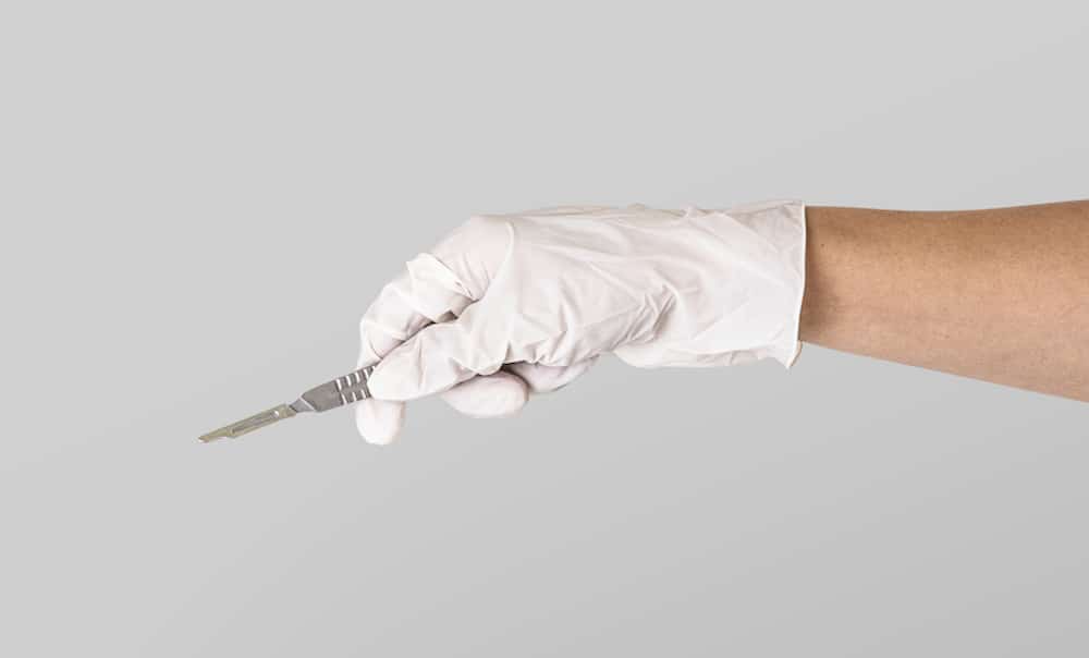 Gloved hand holding scalpel