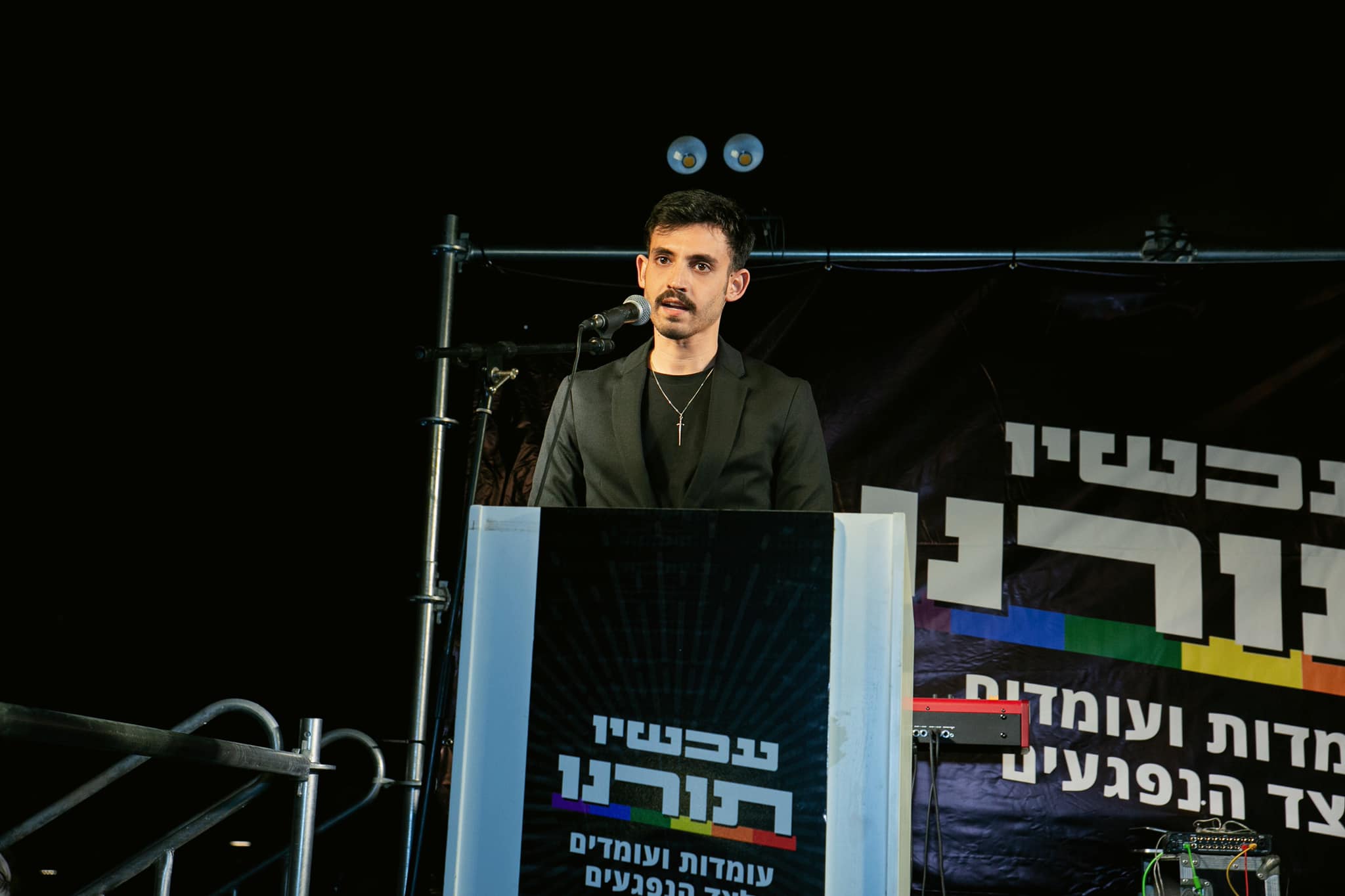 Omri Feinstein speaking at a protest against sexual violence.