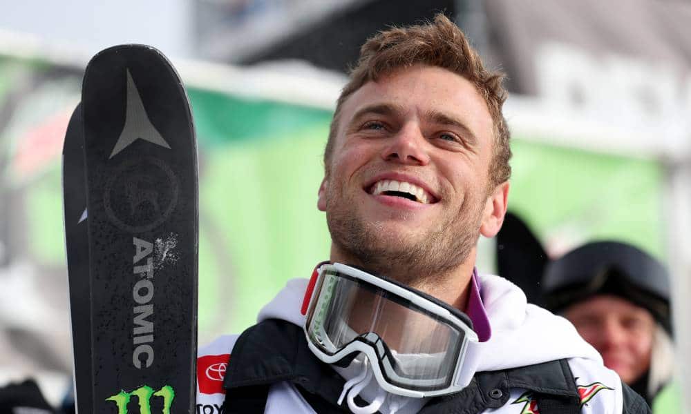 Gus Kenworthy wears ski gear while smiling up