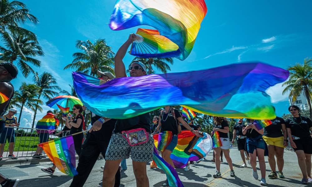 People wave rainbow coloured banners during a Pride parade at the Miami Beach Pride Festival